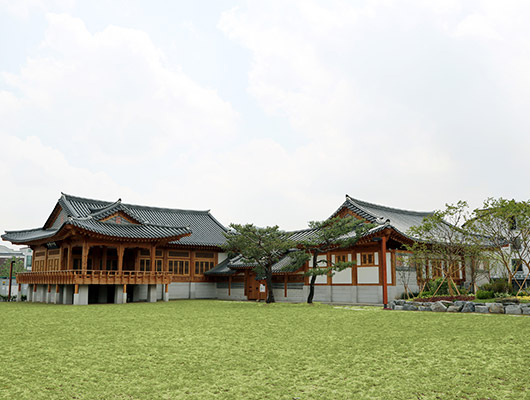 소소한 추석 행사가 진행되는 초로색 잔디 위에 원목으로 만들어진 전통 한옥양식의 수원전통문화관입니다. 
