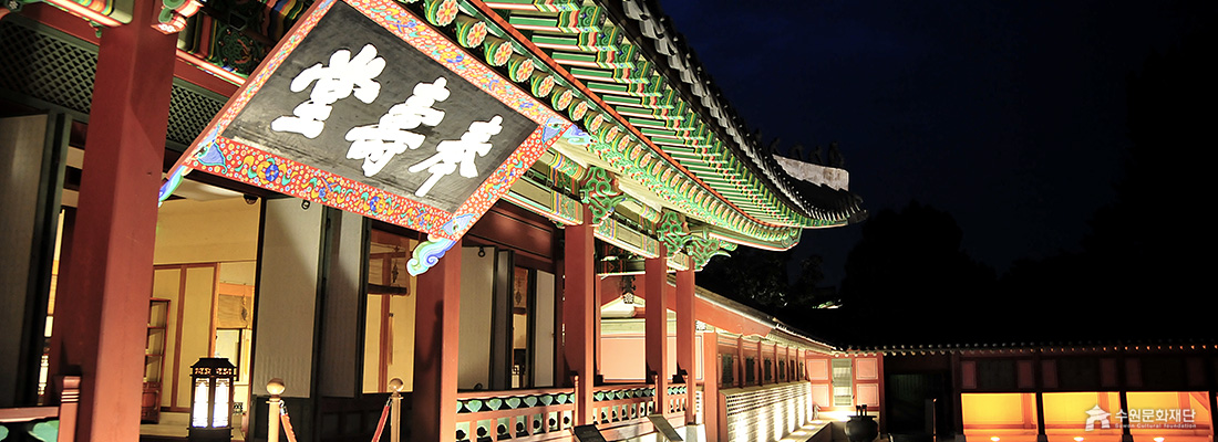 밤에 조명을 받아 화려한 단청이 드러난 봉수당 처마의 근접 촬영 사진. (선택된 큰 사진)