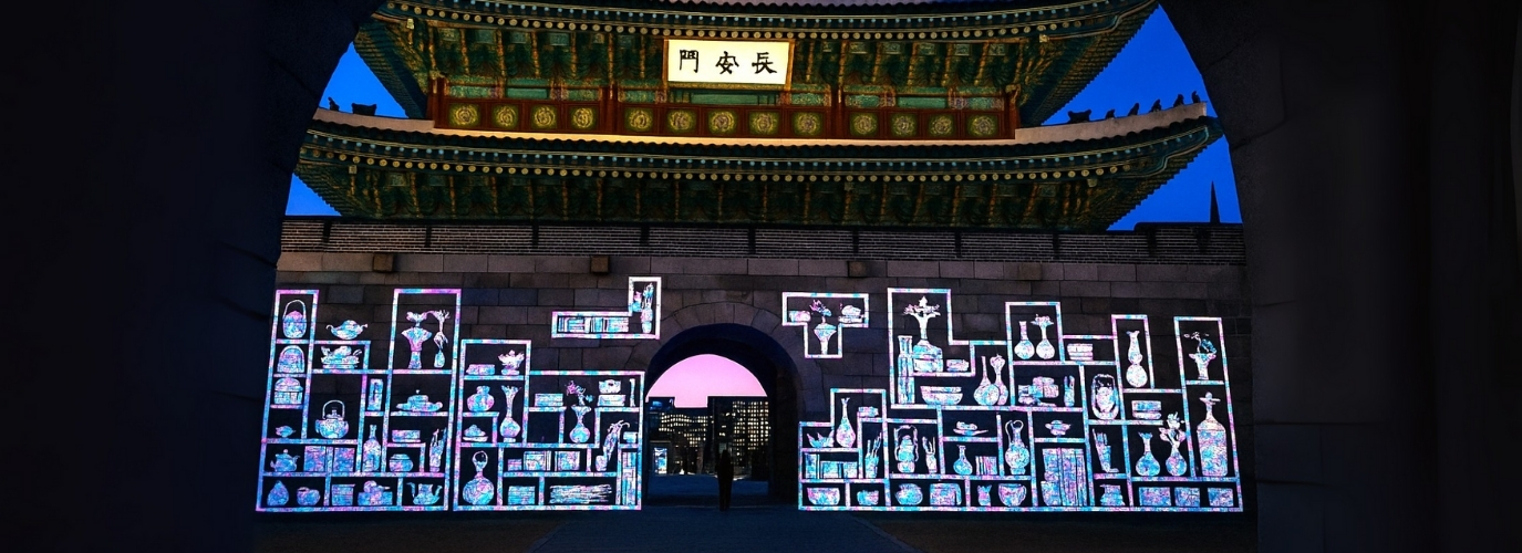 수원 화성 성곽을 스크린 삼아 펼쳐지는 화려한 미디어 아트 쇼. 다채로운 색의 조명과 패턴이 성벽을 가득 채우고 있다.