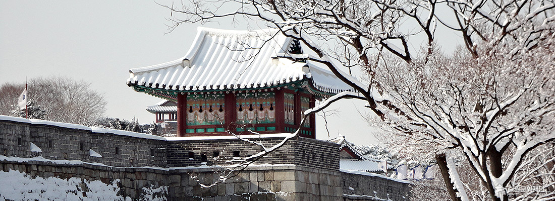 지붕 위에 하얀 눈이 쌓인 수원화성 북포루 모습입니다.